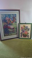 Both framed needlework pictures side by side