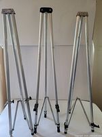 Three silver aluminum tripods upright, collapsed to 35 inches