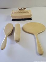 All four items: handheld mirror, hairbrush, clothes brush, closed dragon-lid trinket box