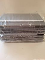 Stack of unopened grey organizers in plastic wrap