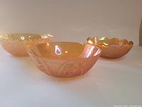 Three marigold carnival glass bowls front view