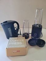 Overview showing kettle, blender base with cups and lids, boxed coffee press