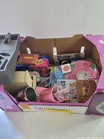 Box showing assorted games, décor and drinkware