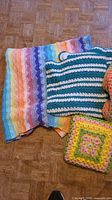 Rainbow blanket, striped green blanket, granny pillow, unfinished peach blanket visible