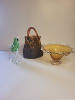 Group view showing bird figurine, bowl and handbag sculpture
