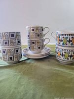 Two patterns of cups and saucers displayed; shows overall quantity