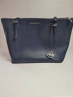 Front view of Michael Kors leather tote showing color, size, MK charm