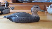 Front-right side view of the Charles Buchanan duck decoy showing detailed feather carvings and painted features.