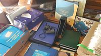 View of two boxes of office supplies including various file folders, binders, a desk light, and motivational quote cards