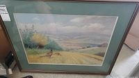 Full view of the framed painting showing pheasants with a landscape background including trees and distant hills.