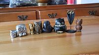 All eight owl figurines lined up, showing size variation and design diversity.