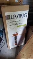 Photo of boxed For Living brand 2-door cabinet showing box label and product image.