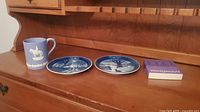 Overall lot including Wedgwood commemorative RCMP cup, small plate, two collector plates, and a Wedgwood booklet