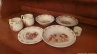 Full set of Bunnykins dishes on wooden shelf with bowls, plates, cups and tumbler