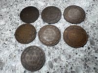 Seven Canadian Large Cent coins laid flat showing denomination sides with dates 1883, 1888, 1917 visible.