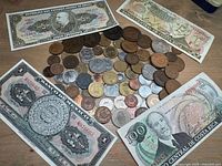 Overview of foreign paper bills and many assorted coins from various countries with intricate designs and portraits visible on bills.