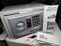 Garrison Electronic Safe EA 20 with key and manuals placed on box