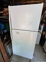 Frontal view of white Kenmore Coldspot refrigerator showing top freezer and bottom fridge door with minor sticker residue.