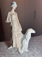 Front and side views of the 13-inch tall ceramic figurine showing the woman and dog with fine detail.