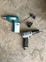 Photo showing Makita cordless drill with charger and Maximum air hammer on floor