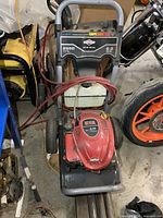 Front view of unit showing engine cover, wheels and soap tank