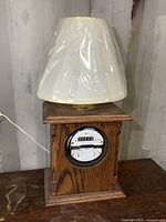 Full view of the lamp showing the wood base, hydro meter front, lamp fixture, and plastic-covered shade.