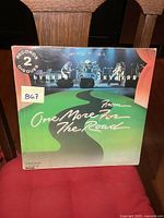 Front cover of Lynyrd Skynyrd 'One More From The Road' double LP showing concert photo and winding road graphic.