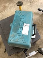 Closed blue Makita branded carrying case with visible wear and dirt spots, showing the overall condition of the storage container for the power planer.