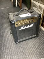 Marshall MG10CD guitar amplifier angled front view showing textured black casing, handle, and gold control panel with knobs and input jacks.