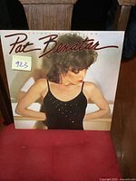 Front cover of the vintage Pat Benatar album Crimes of Passion showing her in a black studded top looking downward with her arms crossed.