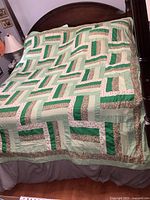 Full view of quilt spread on bed, showing overall pattern and color scheme