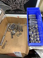 Box with assorted 3/8 drive sockets, extensions, and ratchet.
