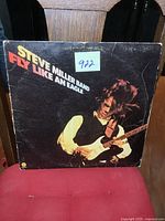 Front cover of Steve Miller Band Fly Like an Eagle vinyl LP showing artist playing guitar and album title in bold.