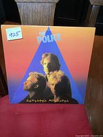 Front cover of The Police 'Zenyatta Mondatta' vinyl record album with band photo and title.