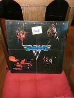 Front cover of Van Halen self-titled LP showing band members and logo, with minor wear and sticker on cover.