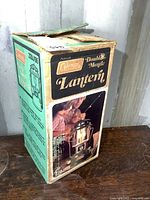 View of the original vintage Coleman box with color graphics and product name Double Mantle Lantern 220J195, showing some wear and aging.