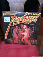 Front cover of ZZ Top Fandango LP showing band members on stage with title and band name.