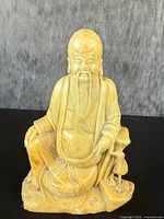 Front view showing seated scholarly figure with long beard, robes, and bird beside him.