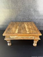 Full view of the antique solid wood low table showing rectangular top and carved apron.