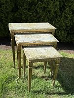 Set of three antique Italian nesting tables placed outdoors in sunlight to show overall condition and scale.