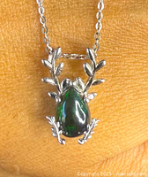 Close-up image of the sterling silver pendant showcasing the natural black opal with surrounding leaf-shaped silver details.