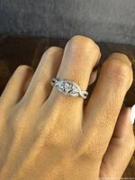 Close-up of the sterling silver engagement-style ring on a finger showing twisted band and clear stones