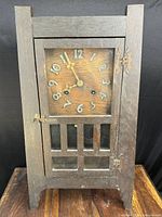 Front view of oak Arts and Crafts mantel clock with glass door closed