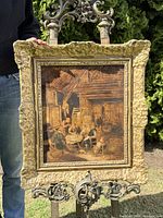 Full view of painting on easel outdoors showing overall composition and frame detail