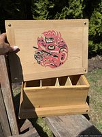 Open view of the box showing five interior compartments for organization or storage beneath the decorated lid.