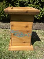 Close-up front view of the cedar umbrella stand showing carved and painted salmon design.