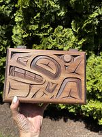 Front view of rectangular box showing full raven motif carved in cedar wood with copper inlay details.