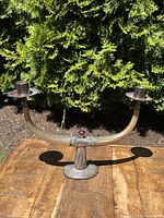 Two-light candelabra hewn from curved horn with sterling silver mounts and base, central red faceted finial, shown front view