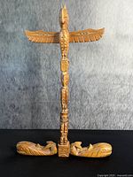 Front view of carved cedar totem pole on base