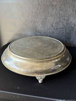 Top and side view of cake stand showing surface, trim, and ornate feet.